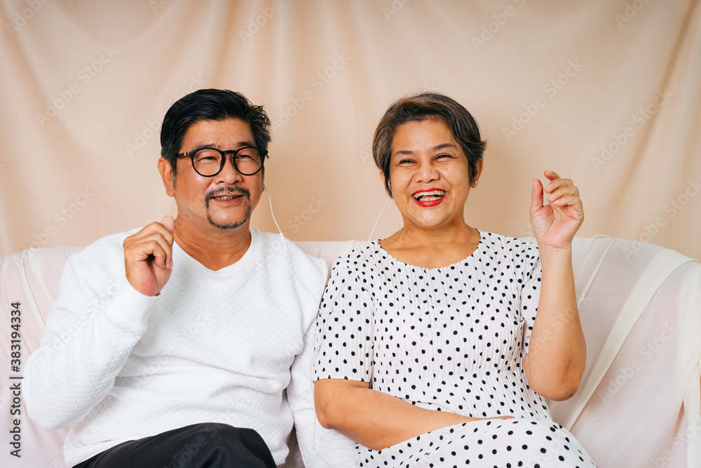 Romantic senior couple sit on a couch enjoy listen to music with earphones. Romantic senior couple sit on a couch enjoy listen to music with earphones.
