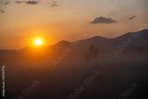 Wild horses run in foggy at sunset. Between Cappadocia and Kayseri, Turkey