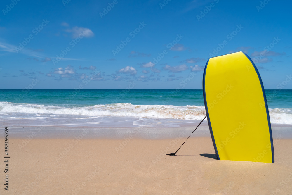 Small surfboards on sand at summer beach with sun light and blue sky.