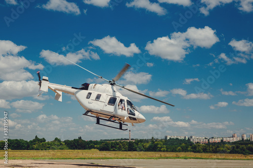 A white helicopter takes off from the runway