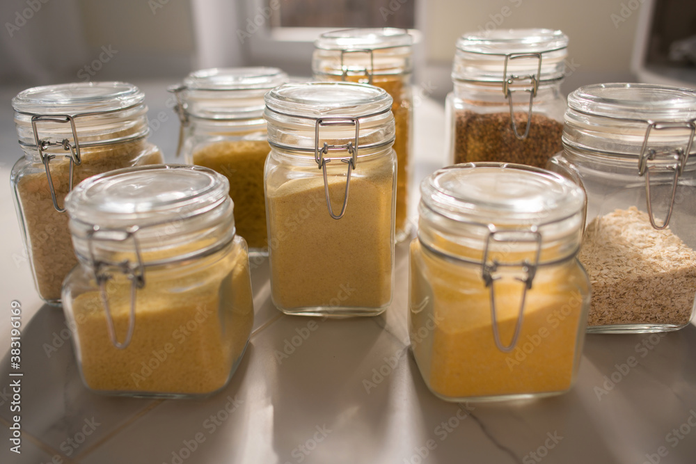 Collection of grain productsin storage jars over on kitchen. Jar of cereals in kitchen cupboard Collection of grain productsin storage jars over on kitchen. Jar of cereals in kitchen cupboard