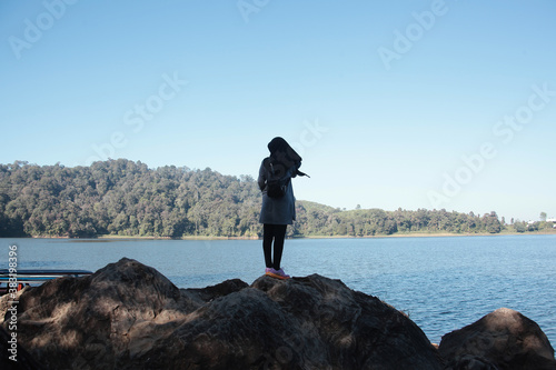 A girl in hijab enjoying the landscape view in the morning at Situ Patenggang Ciwidey West Java Indonesia. photo