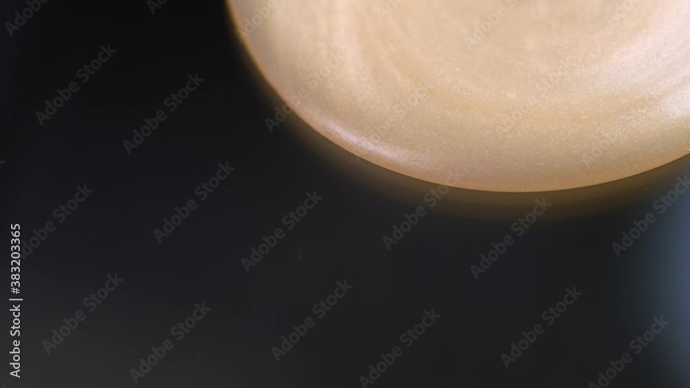 Smooth creamy liquid flowing on black background - close up Smooth creamy liquid flowing on black background - close up