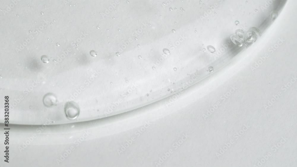 Clear Liquid Gel Fluid Smoothly Slides On A White Surface. - Macro Shot