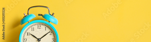 Alarm clock on yellow background, banner. Front view. Copy space.
