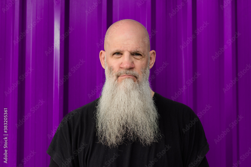 © Ranta Images - Mature handsome bald bearded man against metal sheet wall