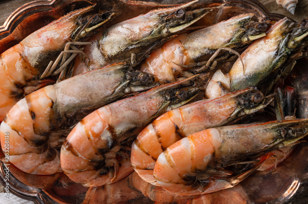 Close-up view of large cooked shrimps on a metal dish. Seafood concept. Organic meal. Horizontal format.