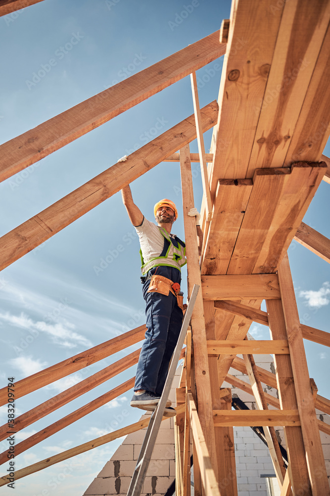 Competent builder doing dangerous work on stepladder Competent builder doing dangerous work on stepladder
