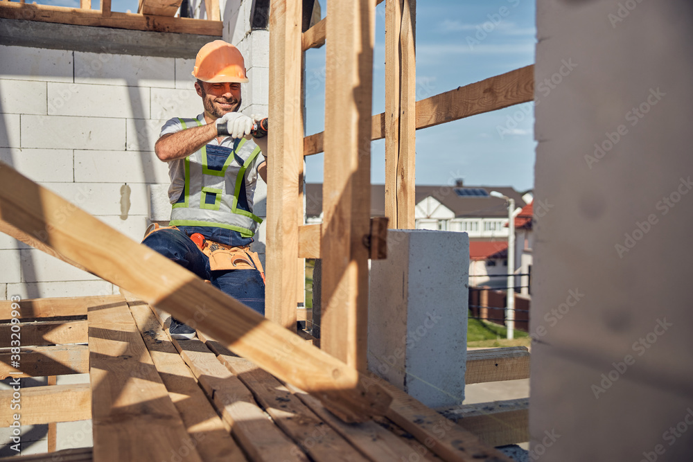 Positive delighted young constructor using his screwdriver Positive delighted young constructor using his screwdriver