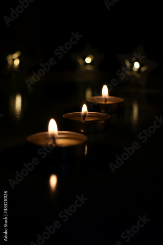 three candles are burning on a dark background. High quality photo