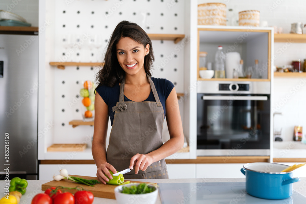 Woman making salad in kitchen smiling and laughing happy and cheerful.