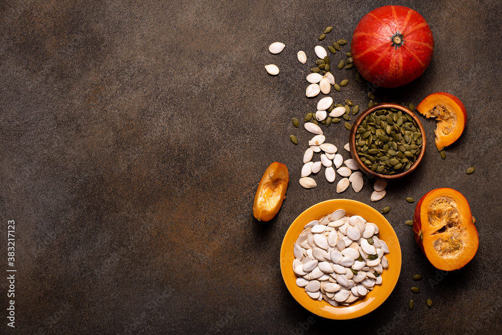 small orange pumpkins and pumpkin seeds on a dark table small orange pumpkins and pumpkin seeds on a dark table