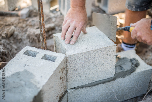 mason making a wall from concrete blocks
