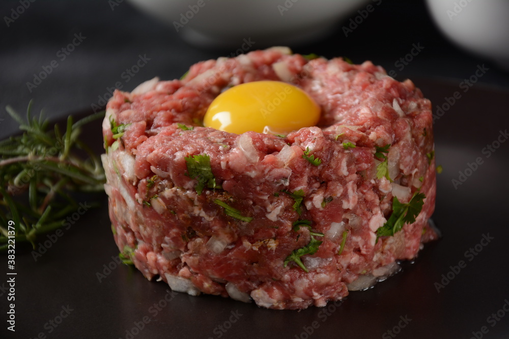 Beef tartare with raw egg, and onions, fresh herbs. French cuisine Beef tartare with raw egg, and onions, fresh herbs. French cuisine