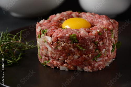 Beef tartare with raw egg, and onions, fresh herbs. French cuisine