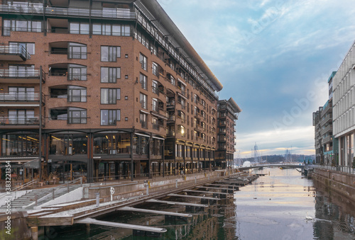 Modern urban architecture in Scandinavia .Oslo, Norway-February, 25, 2020: Akker Brigge area. A light brown modern residential building on the canal. Parking spaces for yachts or boats. 