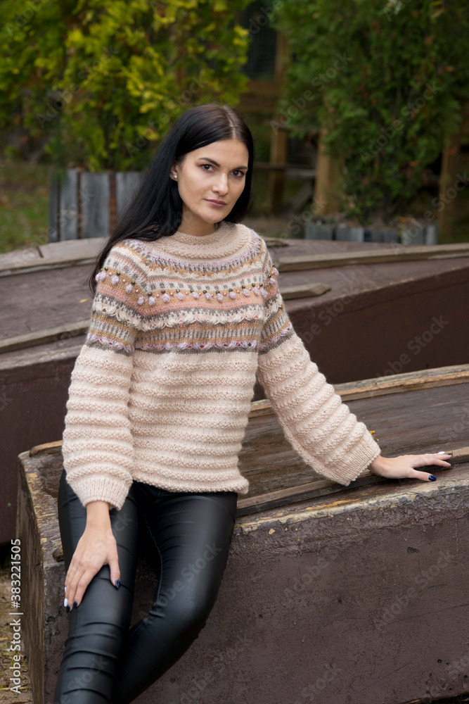 Black-haired woman posing in autumn park in knitted sweater
Black-haired woman posing in autumn park in knitted sweater
