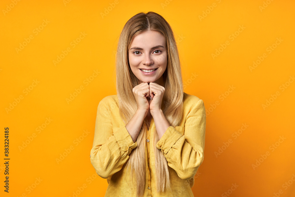 blonde made a wish and squeezes fists on a yellow background blonde made a wish and squeezes fists on a yellow background