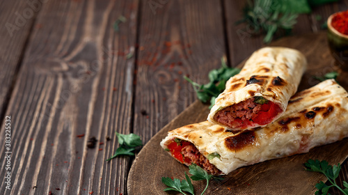 Quadro em tela Traditional Turkish shish - adana kebab, shish kebab with tomatoes on pita bread with vegetables and spices on a wooden background