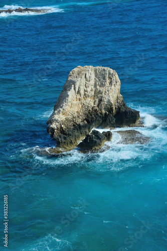 Sea waves breaking on a large rock in the water