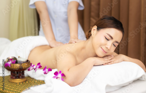 beautiful young Asian woman relaxing with hand massage on naked back body by masseur at beauty spa treatment. relaxing massage