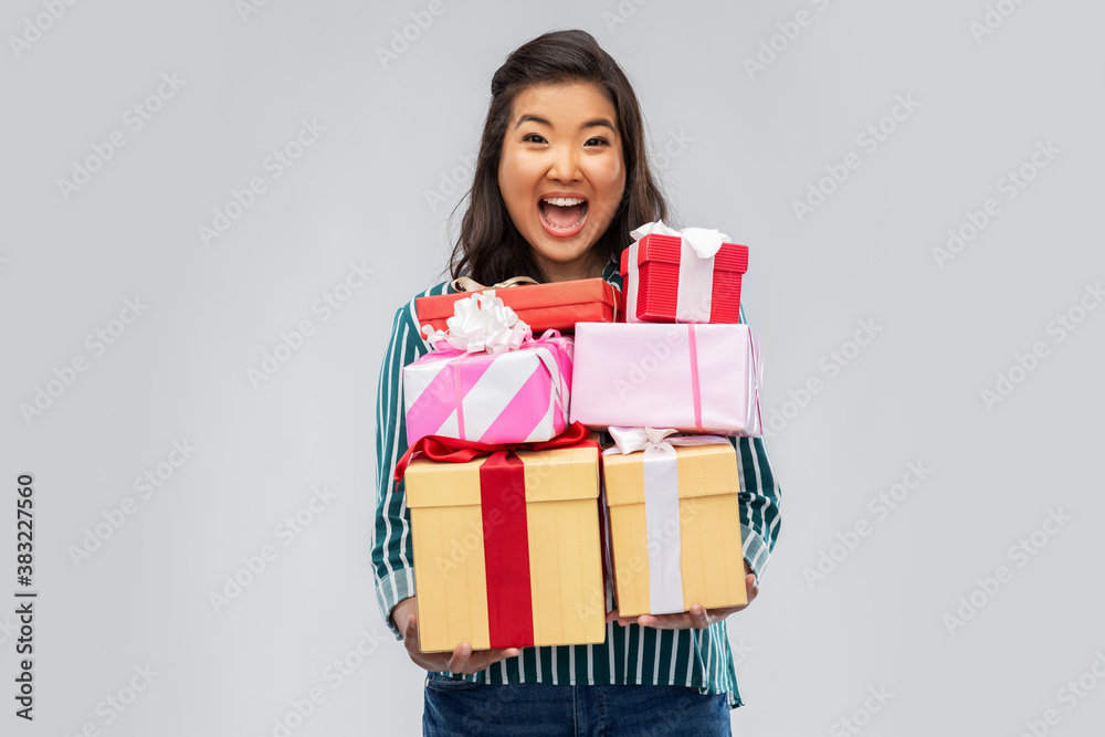 birthday present and surprise concept - happy asian young woman with gift box over grey background birthday present and surprise concept - happy asian young woman with gift box over grey background