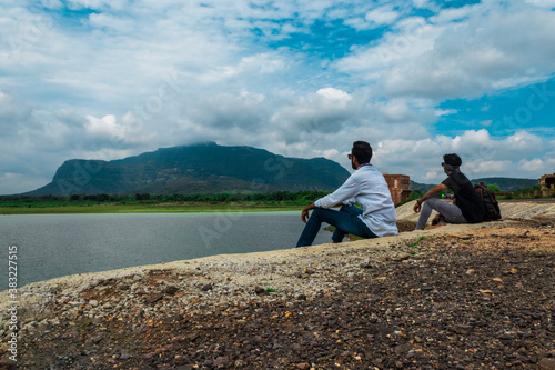 two young man sitting at pavaghad hill station, gujarat, india.