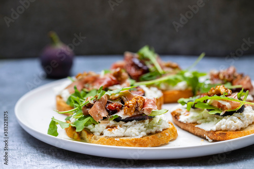 Canapes with ricotta cheese, figs, walnuts and parma ham
