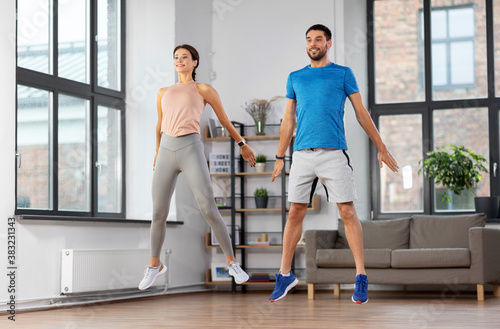 sport  fitness  lifestyle and people concept - smiling man and woman exercising at home