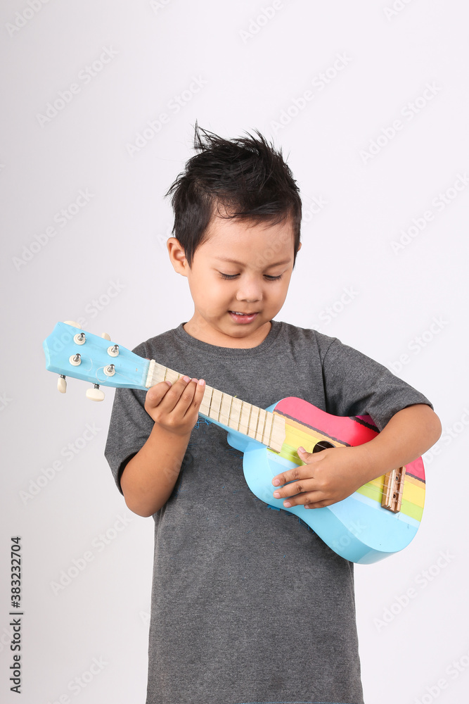Kid playing guitar, kid playing ukulele, isolated on white background, cute boy Kid playing guitar, kid playing ukulele, isolated on white background, cute boy