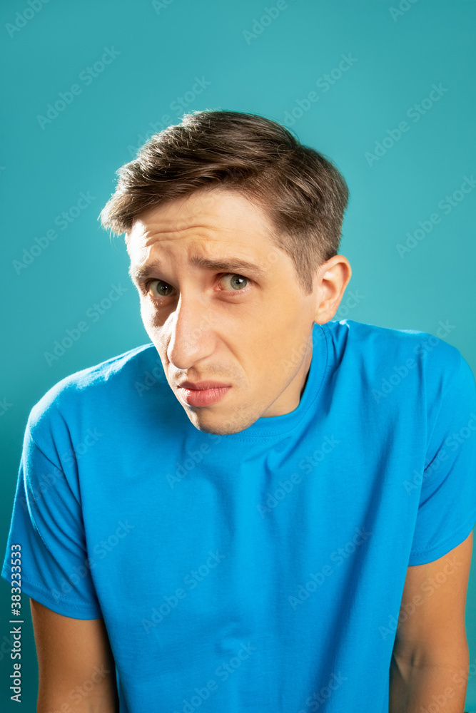Omg wtf. Puzzled man. Unsure emotion. Mean what. Clueless face. Refusal information. Doubtful young guy looking at camera isolated on blue. Omg wtf. Puzzled man. Unsure emotion. Mean what. Clueless face. Refusal information. Doubtful young guy looking at camera isolated on blue.