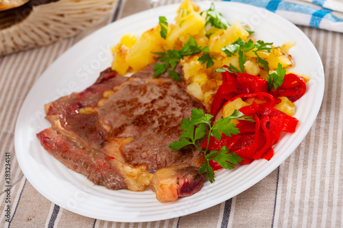 Tasty veal baked with potatoes and peppers served at plate, nobody