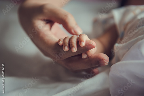Newborn baby holding mother's hand. photo