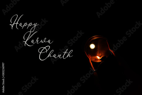 Happy Karwa chauth greeting wish poster card with moon glowing diya on black background photo