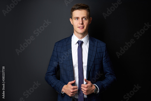portrait of caucasian handsome male in stylish suit posing at camera, isolated over black background. business people concept. in contemplation