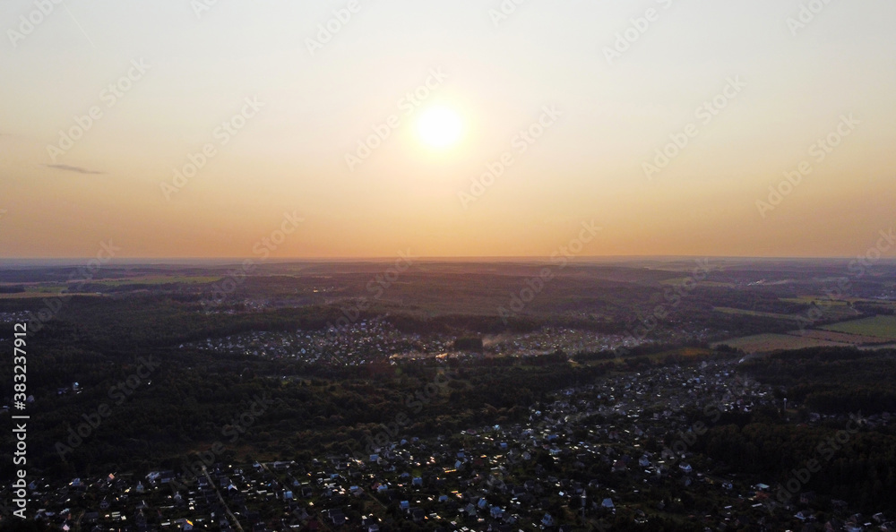 Beautiful top view of the forest landscape at sunset near the suburb