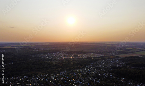 Beautiful top view of the forest landscape at sunset near the suburb © Payllik