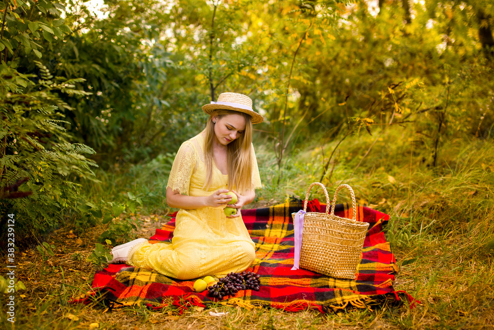 Obraz premium girl in a yellow dress in a straw hat with apples
