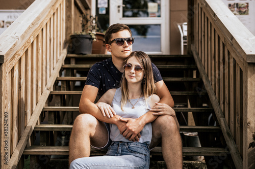 Close up of romantic couple in embrance look away on building background photo