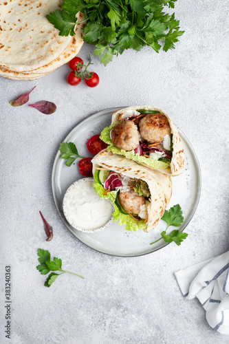 Meatballs in a pita with vegetable and yogurt sauce