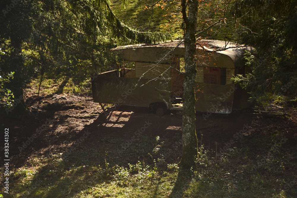 Caravane abandonnée dans la forêt, lieu abandonné, atmosphère lugubre Caravane abandonnée dans la forêt, lieu abandonné, atmosphère lugubre