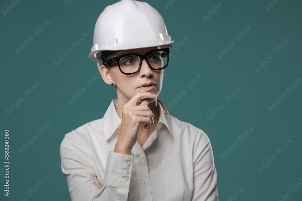 Pensive businesswoman with safety helmet