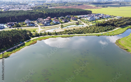 Top view of a beautiful city summer park with a lake and an embankment. 