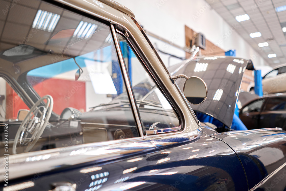 Garage with retro cars. Mechanic in classic car restoration workshop