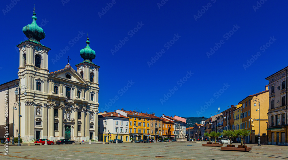 Imposing building of Church of St. Ignatius with two bell towers on Victory Square (Piazza della Vittoria) on sunny autumn day, Gorizia, Italy