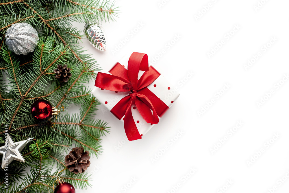 Christmas composition on a white background with a white gift box with a red ribbon with fir branches, toys. View
top with copy space for your congratulations
Christmas composition on a white background with a white gift box with a red ribbon with fir branches, toys. View
top with copy space for your congratulations