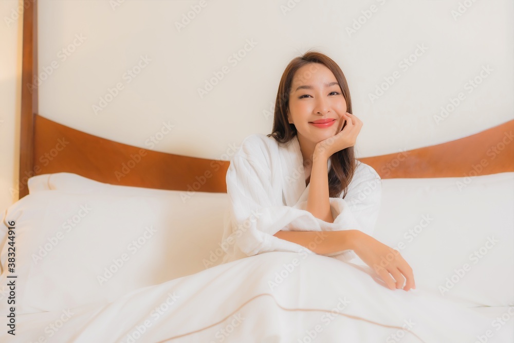 Portrait beautiful young asian woman smile relax on bed in bedroom interior