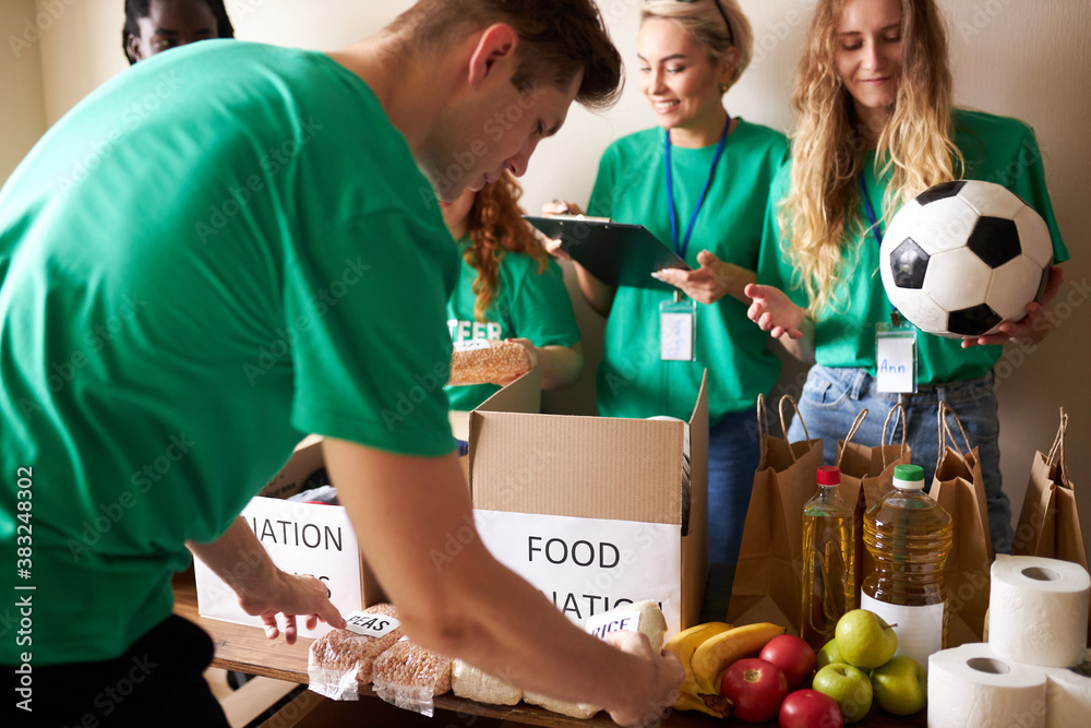 Φωτογραφία active young people enjoys volunteering at food and clothes bank, voluntary company