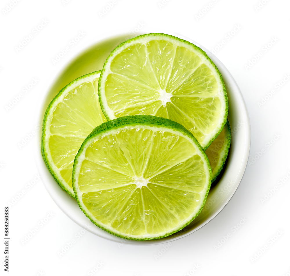 Bowl of lime slices isolated on white, from above