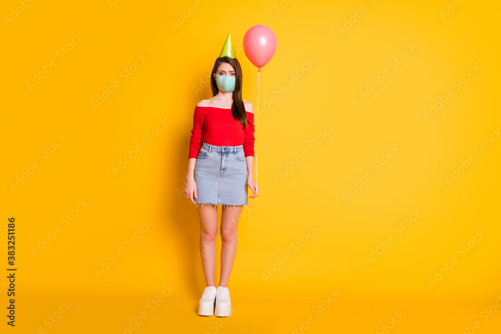 Full size photo of girl in medical mask social distance trend celebrate birthday alone hold balloon wear red top denim skirt legs sneakers isolated over bright shine color background